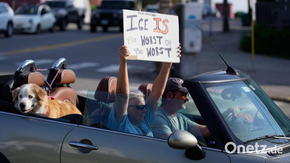 Ein Demonstrant hält ein Schild hoch. Bild: Robert F. Bukaty/AP/dpa
