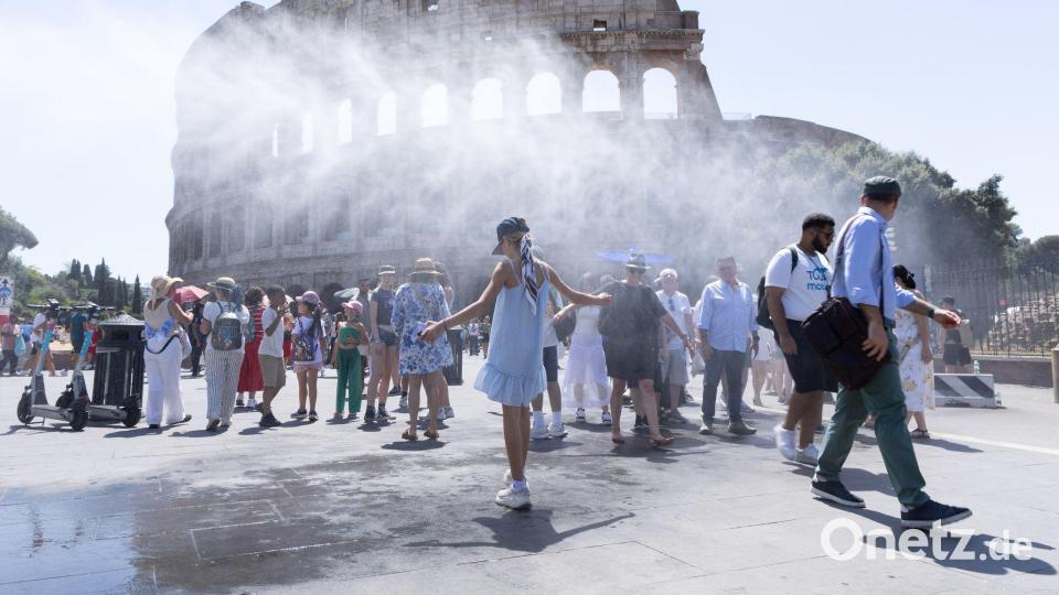 Touristen suchen vor dem Kolosseum in Rom unter dem Sprühnebel Abkühlung. Bild: Matteo Nardone/IPA via ZUMA Press/dpa