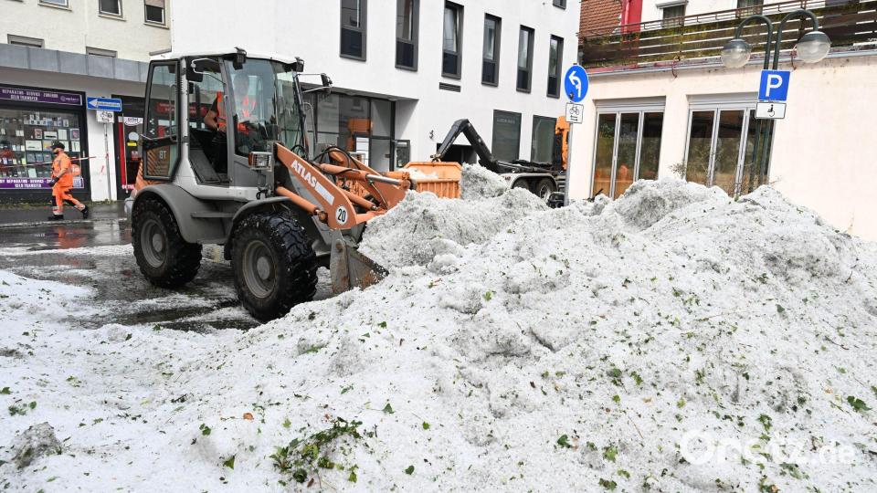 Mitarbeiter der Stadtreinigung entfernen Hagelkörner nach einem Unwetter in Reutlingen. Bild: Bernd Weißbrod/dpa