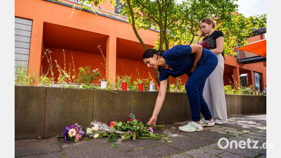 Menschen kommen vorbei und legen Blumen ab. Bild: Andreas Arnold/dpa
