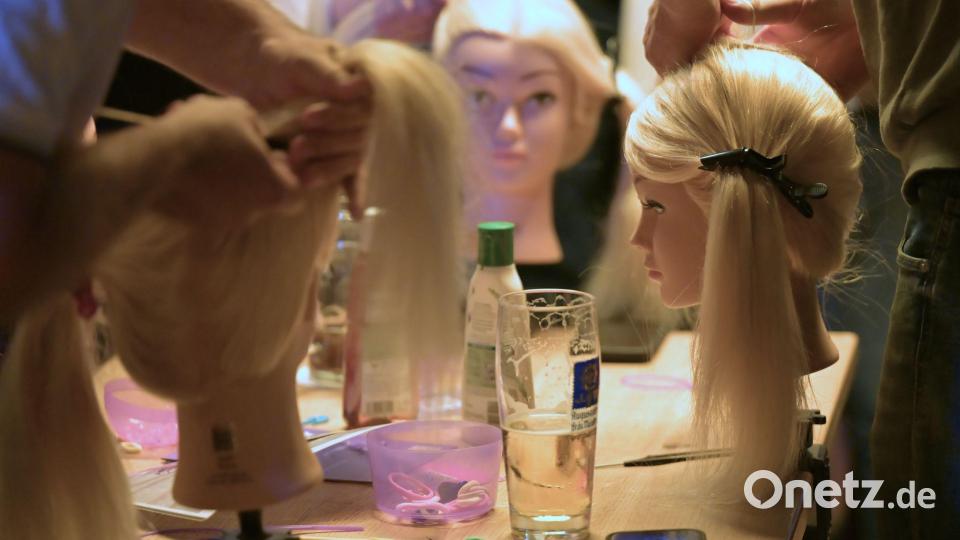 Bei Bier und ganz ohne Druck üben die Väter verschiedene Frisuren für lange Haare. Bild: Malin Wunderlich/dpa