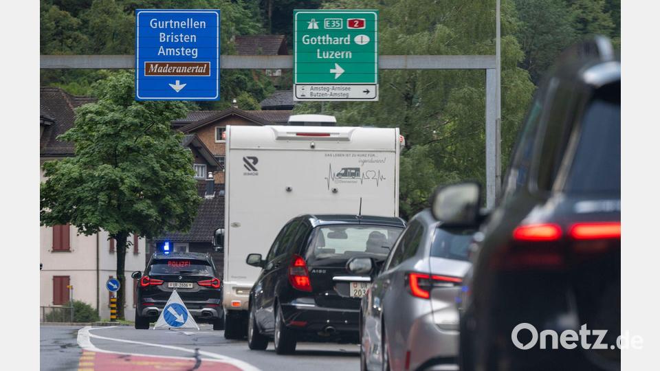 Die Polizei leitet ausweichende Autos in Amsteg wieder auf die Autobahn. Bild: Urs Flueeler/KEYSTONE/dpa