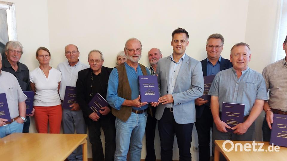 Im Beisein der Gäste übergab der Autor Ulrich Wohlgemuth an Bürgermeister Rudolf Teplitzky den frisch fertiggestellten Quellenband über Streitfälle zwischen der Hofmark Fuchsberg und dem Pflegamt Murach. Bild: Georg Lang