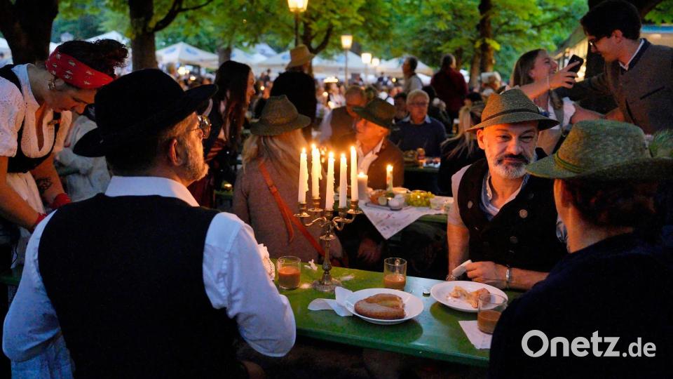 Bei Kerzenschein: Wenn die Stadt noch schläft, feiern Tausende Menschen im Englischen Garten den Kocherlball. Bild: Uwe Lein/dpa