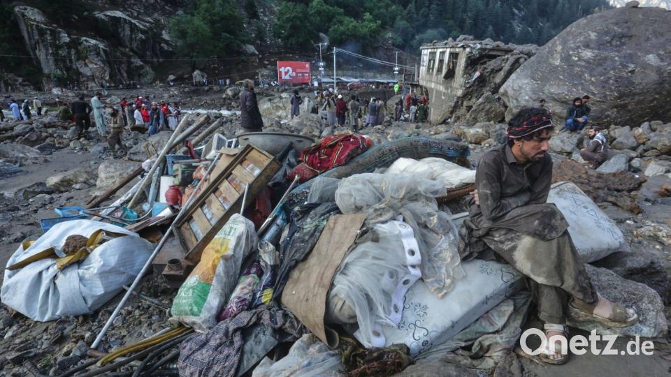 Ein Mann sitzt nach schweren Überschwemmungen in Afghanistan neben seinen geretteten Habseligkeiten. Bild: Wahidullah Kakar/AP/dpa