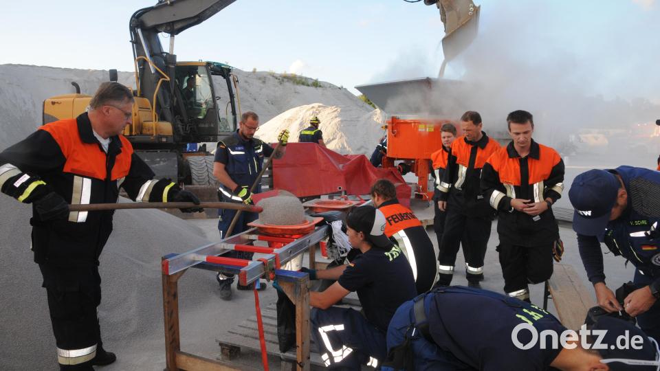 Übung für den Ernstfall: Vorne werden die Sandsäcke nach herkömmlicher Methode per Schaufel und Trichter gefüllt, hinten schüttet der Bagger Nachschub in die Sandsackmaschine. Bild: ge