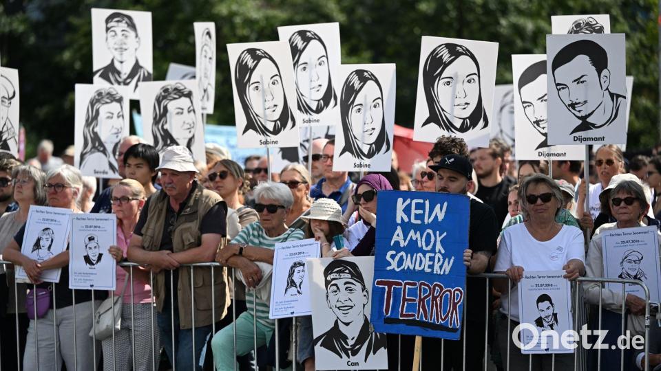 Zuschauer des Gedenkaktes der Landeshauptstadt München anlässlich des 10. Jahrestags des Attentats am Olympia-Einkaufszentrum halten Plakate mit Portraits der Opfer. Bild: Sven Hoppe/dpa