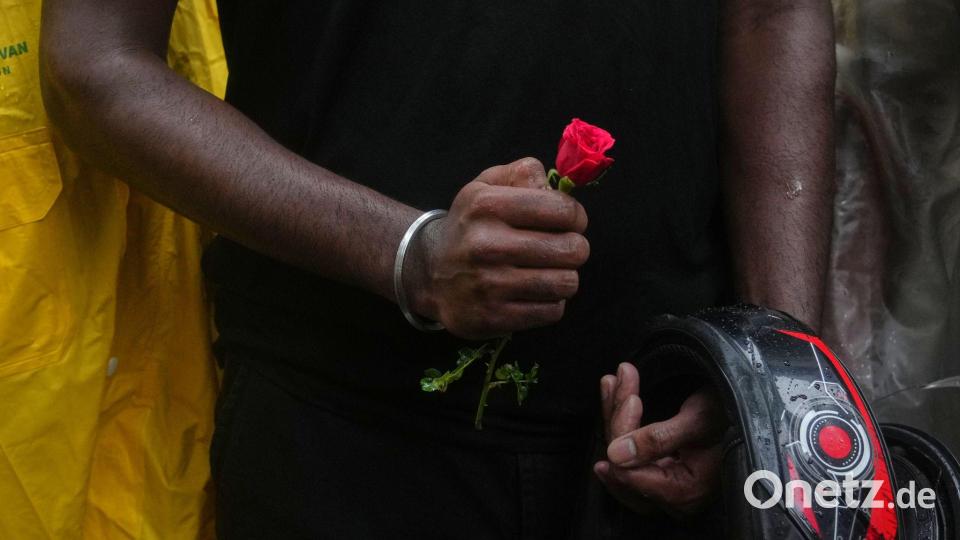 Ein Teilnehmer einer Demonstration hält während einer Kundgebung für Bildungsreformen im Rahmen der anhaltenden Protestbewegung der „Cockroach Janta Party“ eine Blume in der Hand. Bild: Rafiq Maqbool/AP/dpa