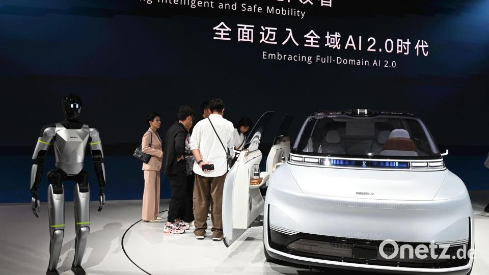Hier präsentiert Geely ein Auto samt humanoidem Roboter auf einer Automesse in Peking. Nun wagt die Firma den Sprung nach Spanien, um dort Autos zu bauen. Bild: Johannes Neudecker/dpa