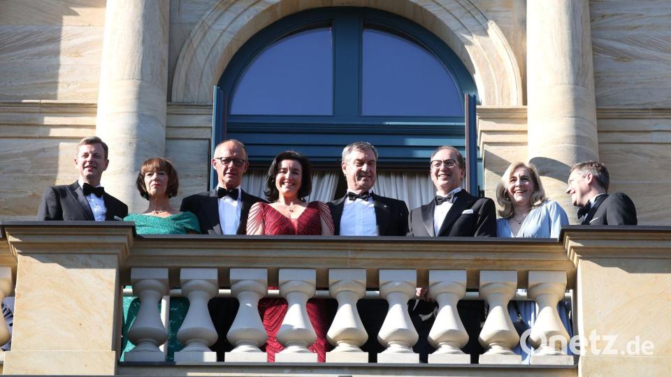 Auf dem Balkon des Festspielhauses genießt die Polit-Prominenz die Sonnenstrahlen. Bild: Karl-Josef Hildenbrand/dpa