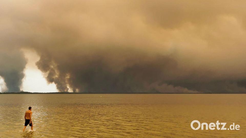 Strandbesuch vor Rauchwolken in Lacanau im Südwesten Frankreichs. Bild: Maximilien Lamy/AFP/dpa