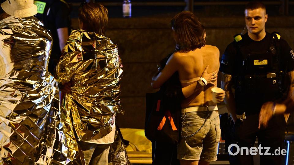 Menschen hüllen sich in Rettungsdecken und umarmen sich. Bild: Fabian Sommer/dpa