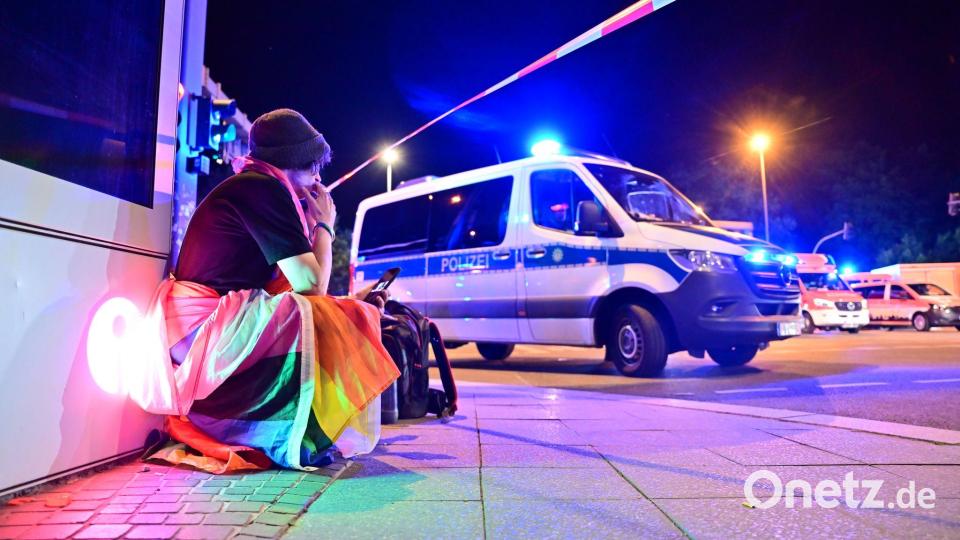 Marlon ist in eine Pride-Fahne gehüllt und hockt neben einem Polizeifahrzeug nach dem Abbruch des Christopher Street Day in Berlin. Bild: Sebastian Gollnow/dpa