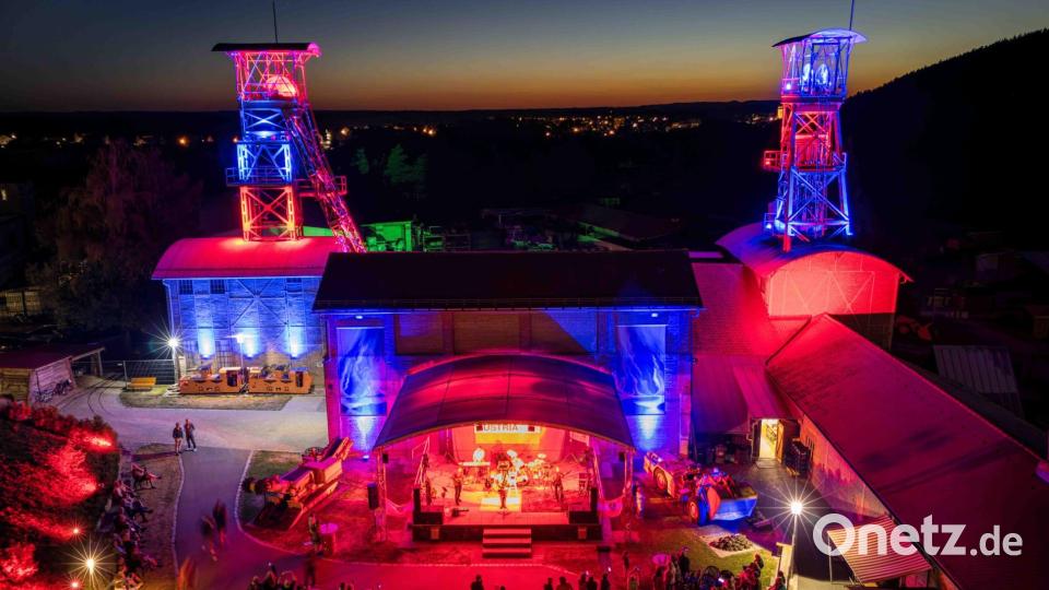 Das Classic-Rock-Festival G:O:A findet auf dem Gelände des Bergbaumuseums Maffeischächte statt. Neben der Bühnenbeleuchtung werden in der Dämmerung auch die Fördertürme illuminiert. Bild: Michel Grüner / Förderverein Maffeispiele