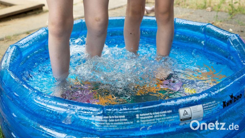 Kinder stehen in einem Planschbecken. Bild: Sebastian Kahnert/dpa
