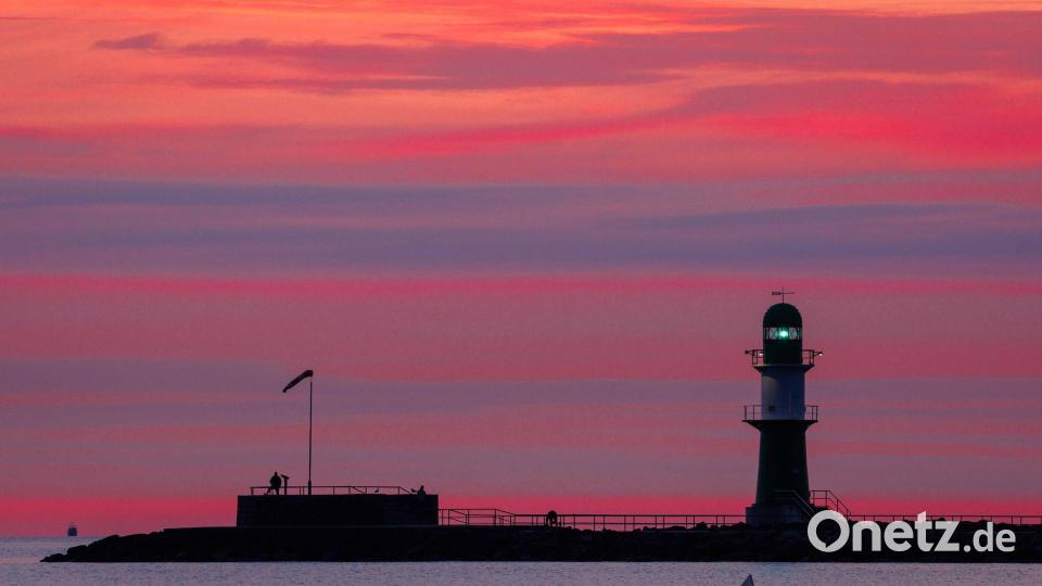 Leuchtfeuer auf der Mole in Warnemünde blinkt vor Sonnenaufgang Bild: Jens Büttner/dpa