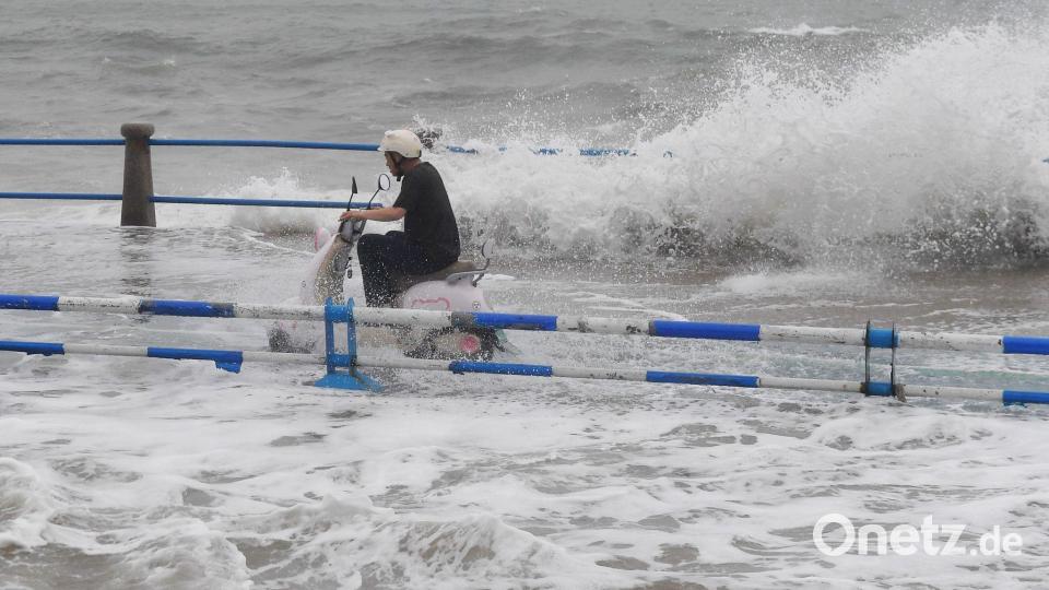An der Küste von Shandong (China): Motorradfahrer trotzt den Wellen vor Taifun „Bavi“ Bild: Uncredited/CHINATOPIX via AP/dpa