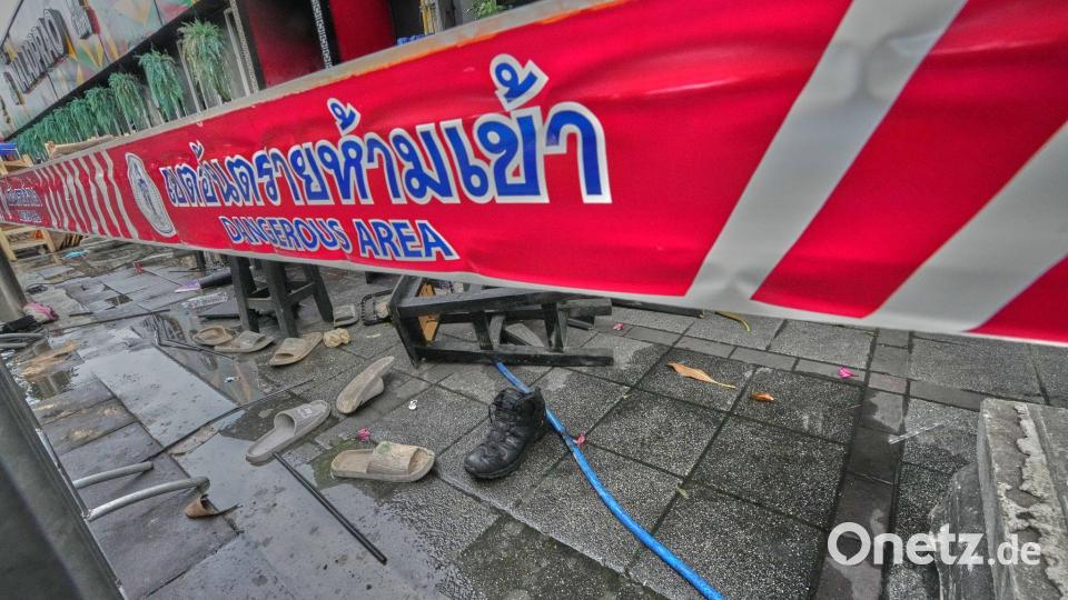 Vor einem Pub in Bangkok liegen nach einem Brand verstreute Schuhe. Bild: Sakchai Lalit/AP/dpa