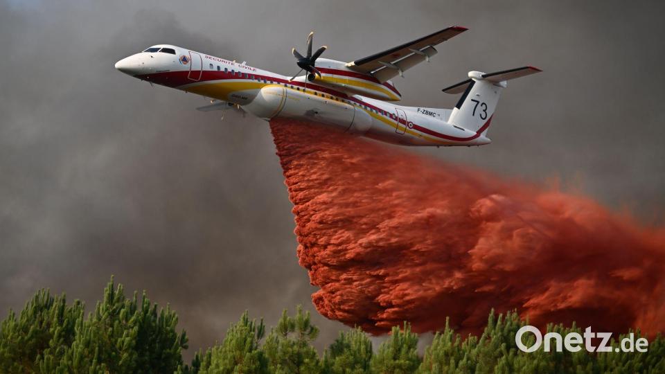 Eine De Havilland Canada Dash 8-400 versprüht Löschmittel, während sie bei den Waldbränden im Südwesten Frankreichs über einen Wald fliegt. Bild: Emma Da Silva/AP/dpa