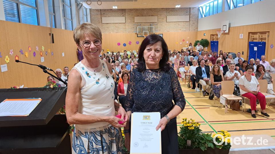 Schulamtsdirektorin Renate Vettori (links) überreicht Rektorin Maria Karg-Pirzer im Beisein zahlreicher Gäste die Urkunde zur Versetzung in den Ruhestand. Bild: Rudolf Hirsch