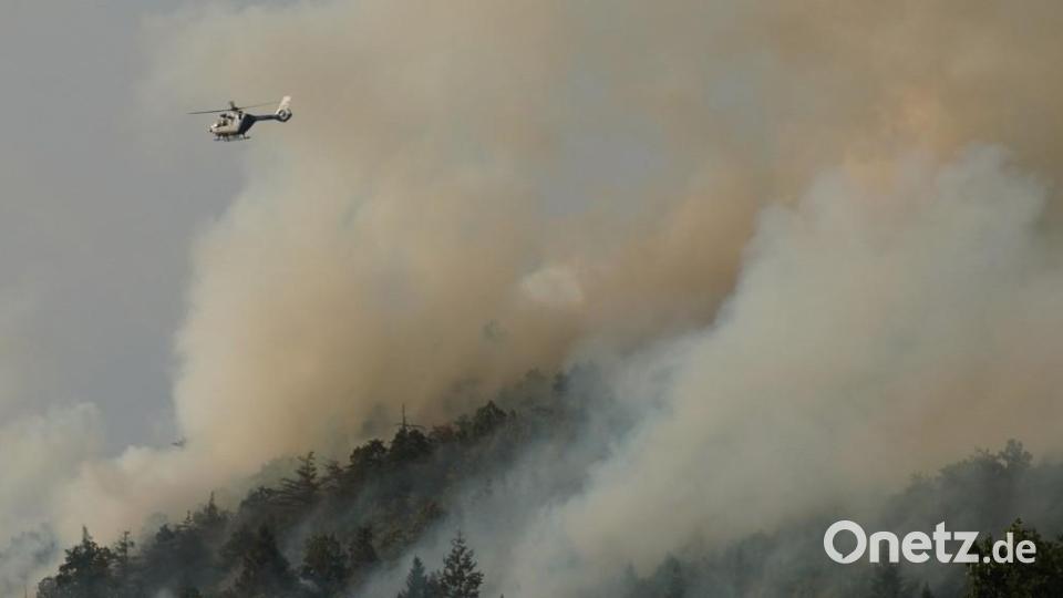 Ein Hubschrauber fliegt über den Johannisberg in Freudenberg. Dicke Rauchschwaden zeugen am Freitagabend von einem ausufernden Waldbrand. Die Menschen sind aufgerufen, Fenster und Türen geschlossen zu halten. Bild: Rudi Wilhelm