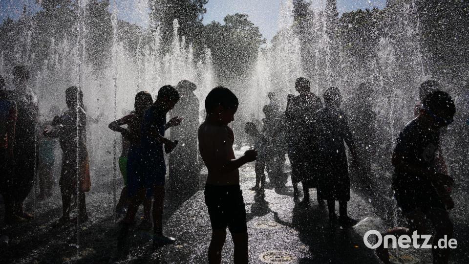 Menschen kühlen sich während einer Hitzewelle vor den Toren der Altstadt von Jerusalem in einem Springbrunnen ab. Bild: Mahmoud Illean/AP/dpa