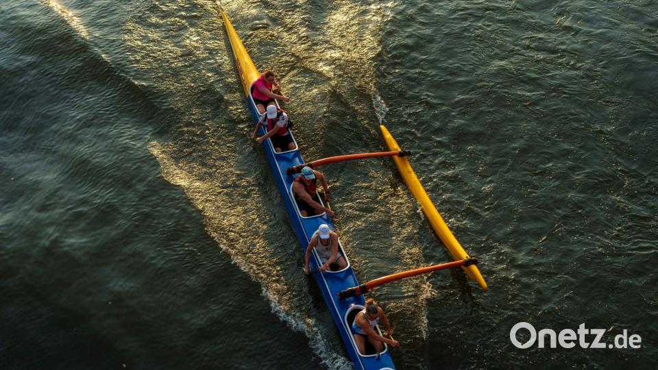 Eine Crew von Wassersportlern trainiert im Abendlicht mit einem Auslegerkanu auf dem Main in Frankfurt. Bild: Andreas Arnold/dpa