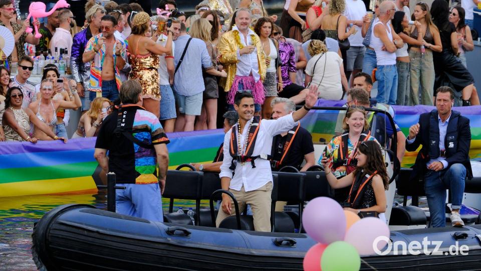Der niederländische Ministerpräsident Rob Jetten steht auf einem Boot und winkt während der Canal Parade in Amsterdam. Bild: Patrick Post/AP/dpa