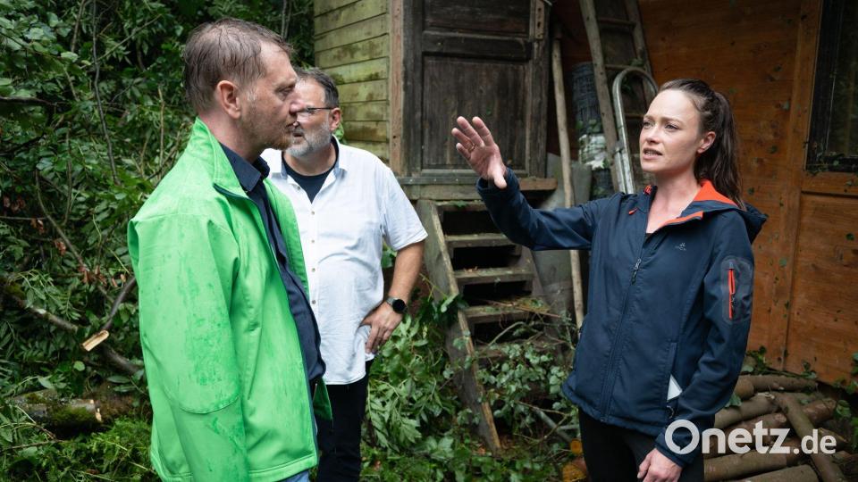 Das Unwetter hat einen Imbiss am Amselsee verwüstet - Sachsens Ministerpräsident Michael Kretschmer spricht mit der TV- und Eventköchin Verena Leister. Bild: Sebastian Kahnert/dpa