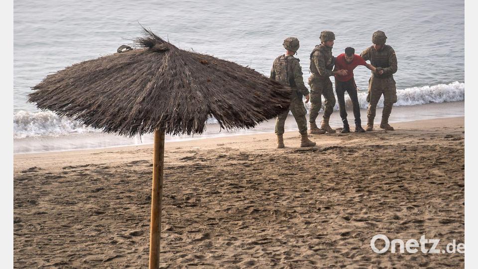 Soldaten der spanischen Armee leisten einem Migranten Hilfe, der von Marokko aus zur spanischen Exklave Ceuta geschwommen ist. Bild: Antonio Sempere/AP/dpa