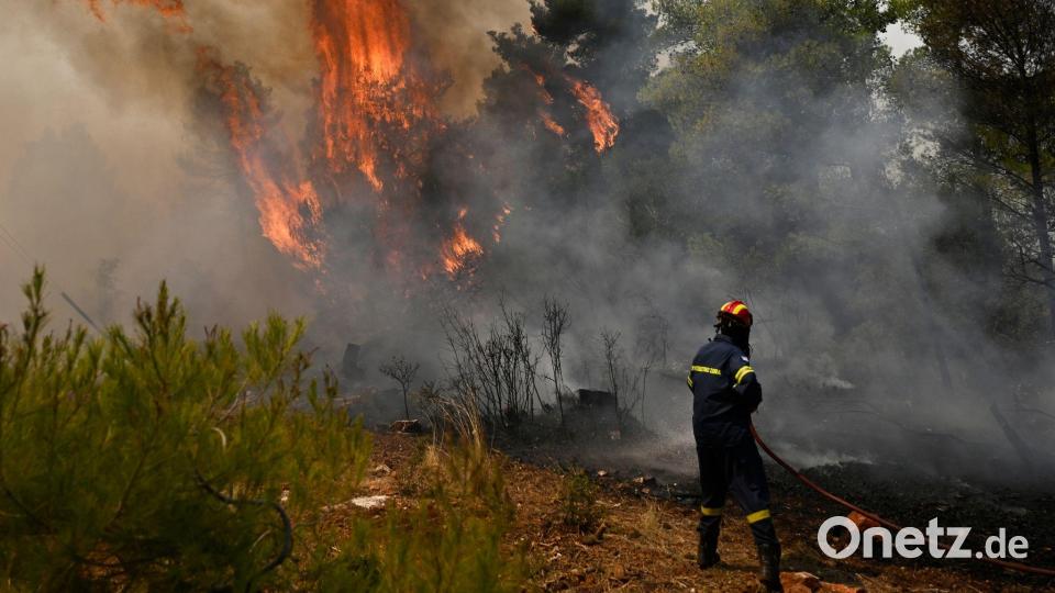 Ein Feuerwehrmann bereitet sich bei einem Waldbrand nordwestlich von Athen darauf vor, die Flammen zu löschen. Bild: Michael Varaklas/AP/dpa