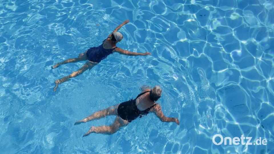 Zwei Frauen erfrischen sich in einem Außenbecken eines Schwimmbads. Bild: Thomas Warnack/dpa