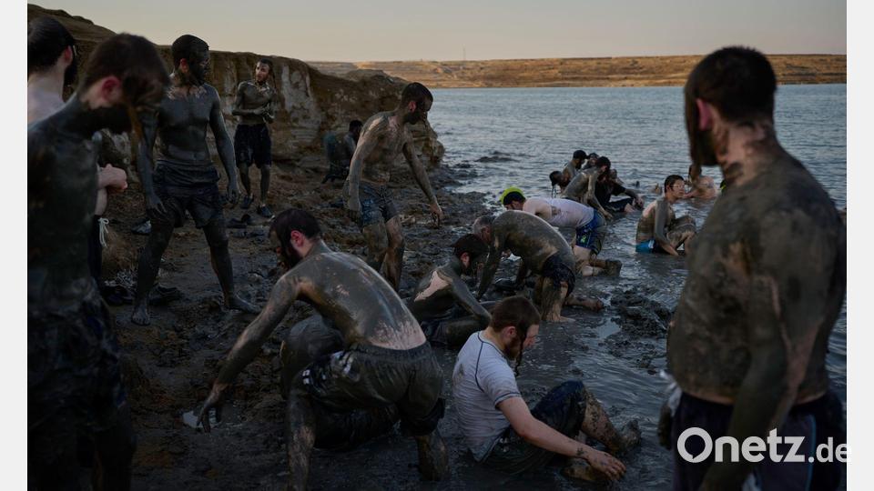 Ultraorthodoxe jüdische Männer bedecken sich am Toten Meer im Westjordanland mit Schlamm. Bild: Ohad Zwigenberg/AP/dpa