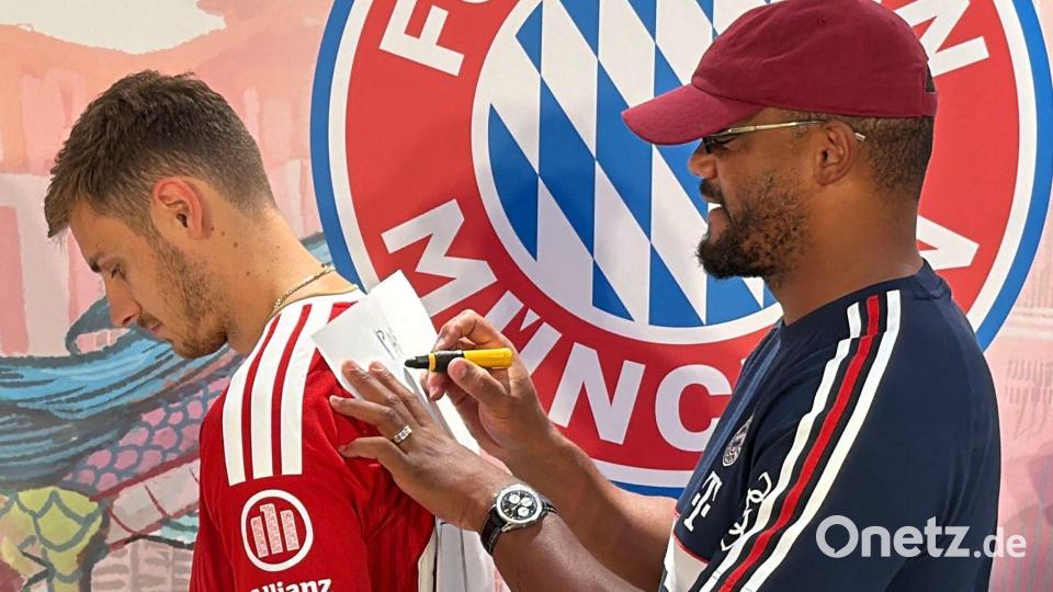 Trainer Vincent Kompany (r) malt - und Josip Stanisic muss raten. Bild: Christian Kunz/dpa