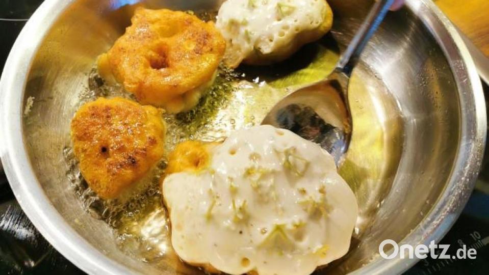 Die Hollerküchel werden im heißen Fett herausgebacken. Nachdem der Stiel abgeschnitten wurde, werden sie gewendet. Köstlich schmeckt dazu ein säuerliches Mus oder Kompott. Bild: Heike Heindl/exb