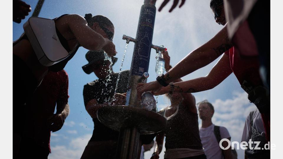Nicht nur in Paris scharen sich die Menschen in diesem Sommer um Trinkbrunnen. (Archivbild) Bild: Christophe Ena/AP/dpa