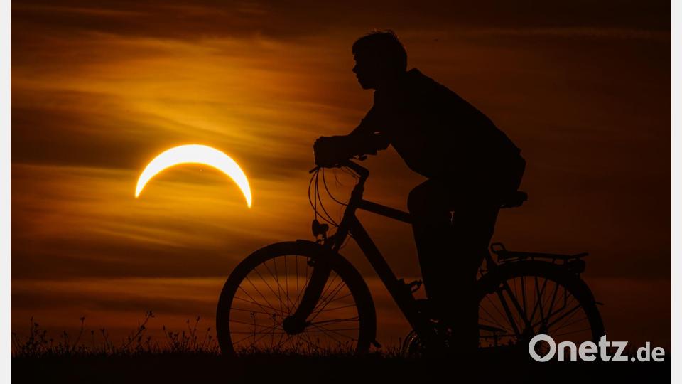 Ein Junge auf einem Fahrrad betrachtet die partielle Sonnenfinsternis in Jacobsdorf, im östlichen Brandenburg. Bild: Patrick Pleul/dpa