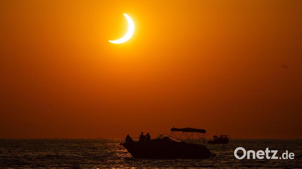 Menschen beobachten die Sonnenfinsternis von einer Yacht aus vor der Küste von Ibiza. Bild: Germán Lama/EUROPA PRESS/dpa