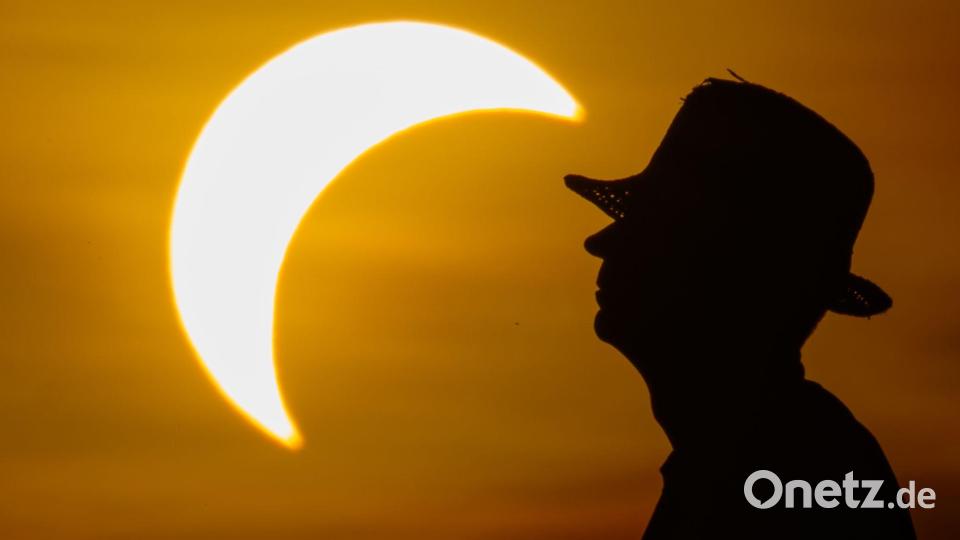 Ein Mann betrachtet die partielle Sonnenfinsternis im östlichen Brandenburg. Bild: Patrick Pleul/dpa