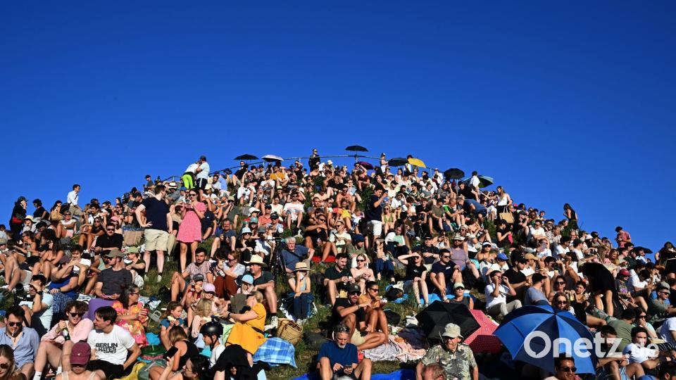 Menschen betrachten eine partielle Sonnenfinsternis am Olympiaberg im Münchner Olympiapark. Bild: Felix Hörhager/dpa