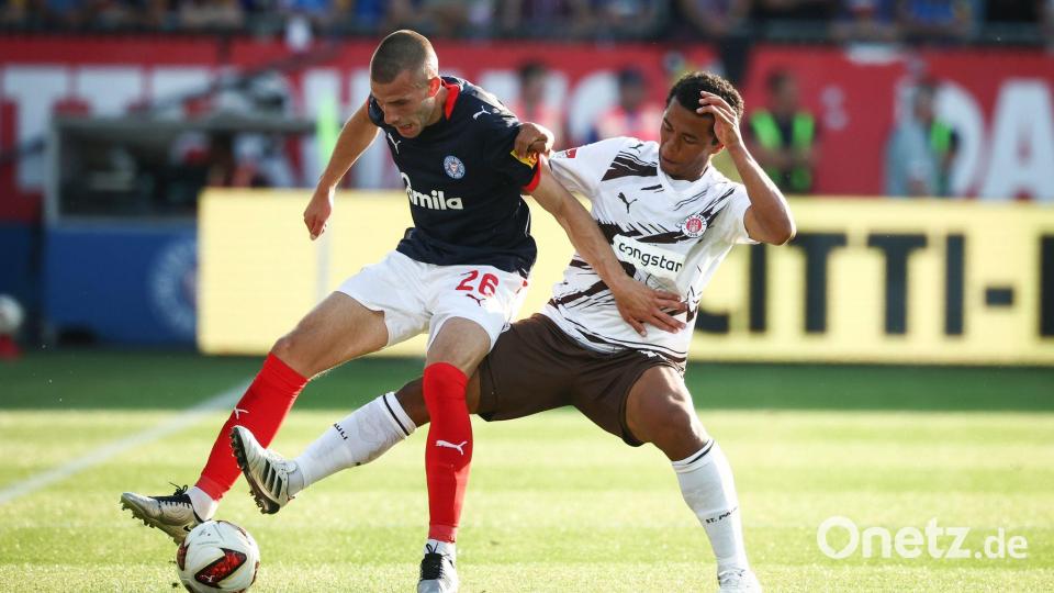 Kiels David Zec (l) wird von St. Paulis Joel Fujita attackiert. Bild: Christian Charisius/dpa