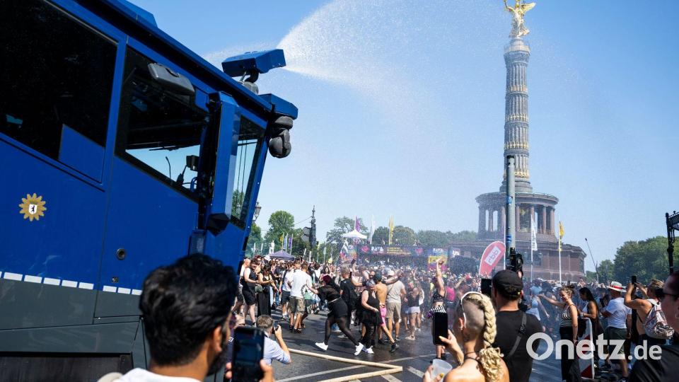 Ein Wasserwerfer der Polizei verschafft den Ravern etwas Abkühlung. Bild: Christophe Gateau/dpa
