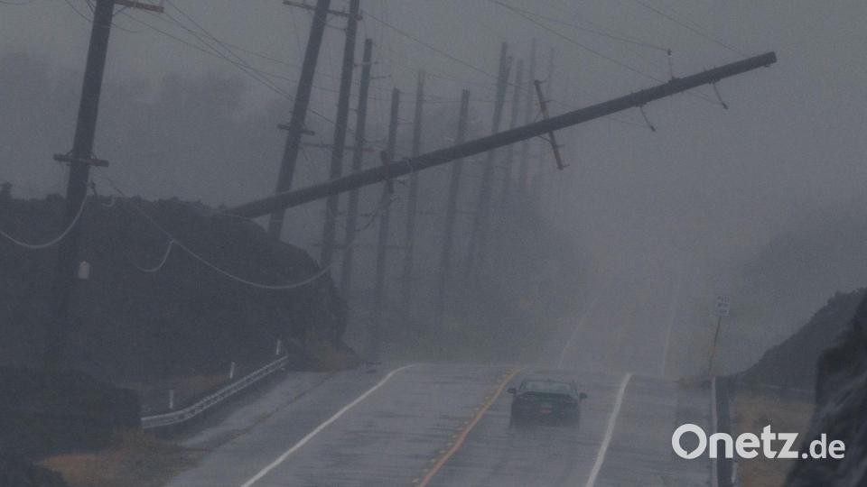 Ein Fahrzeug fährt in der Nähe von Ocean View auf Hawaii während des Hurrikans „Lala“ an einem umgestürzten Strommast vorbei, der über dem Mamalahoa Highway hängt. Bild: Stephen Lam/San Francisco Chronicle/AP/dpa