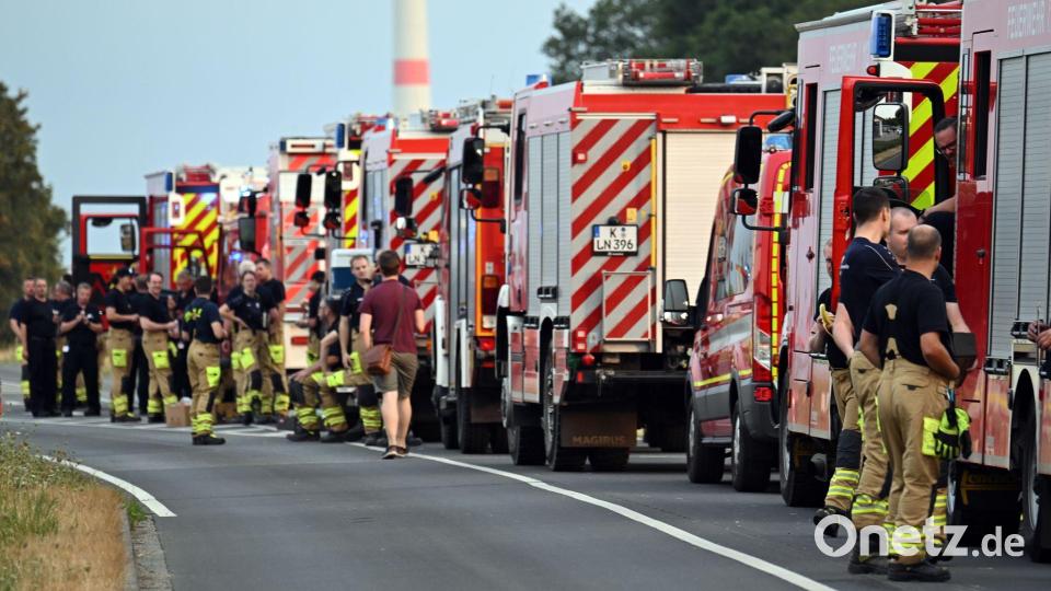 Zahlreiche Kräfte der Feuerwehr stehen an einer Straße. Bild: Federico Gambarini/dpa