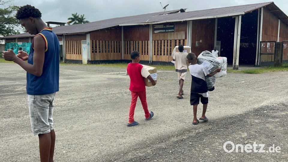 Kinder bringen die Pakete ins Dorf. Bild: Philipp Znidar/dpa