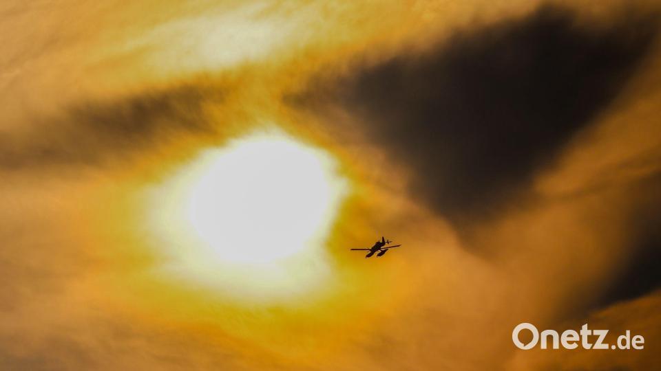 Durch dunkle Rauchschwaden: Ein schwedisches Löschflugzeug fliegt über dem Brandgebiet im Hohen Venn. Bild: Christoph Reichwein/dpa