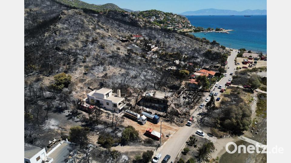 Nach dem Feuer auf der griechischen Insel Salamis ist ein Berghang verbrannt und voll Asche. Bild: Thanassis Stavrakis/AP/dpa
