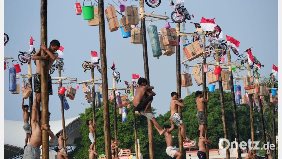 Am Unabhängigkeitstag nehmen Menschen in Indonesien an einem Kletter-Wettbewerb teil. Bild: Tatan Syuflana/AP/dpa