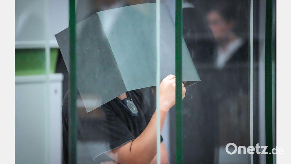 Der Angeklagte hält sich zum Beginn des Prozesstages im Kriminalgericht Moabit einen Aktenordner vors Gesicht. (Archivbild) Bild: Soeren Stache/dpa