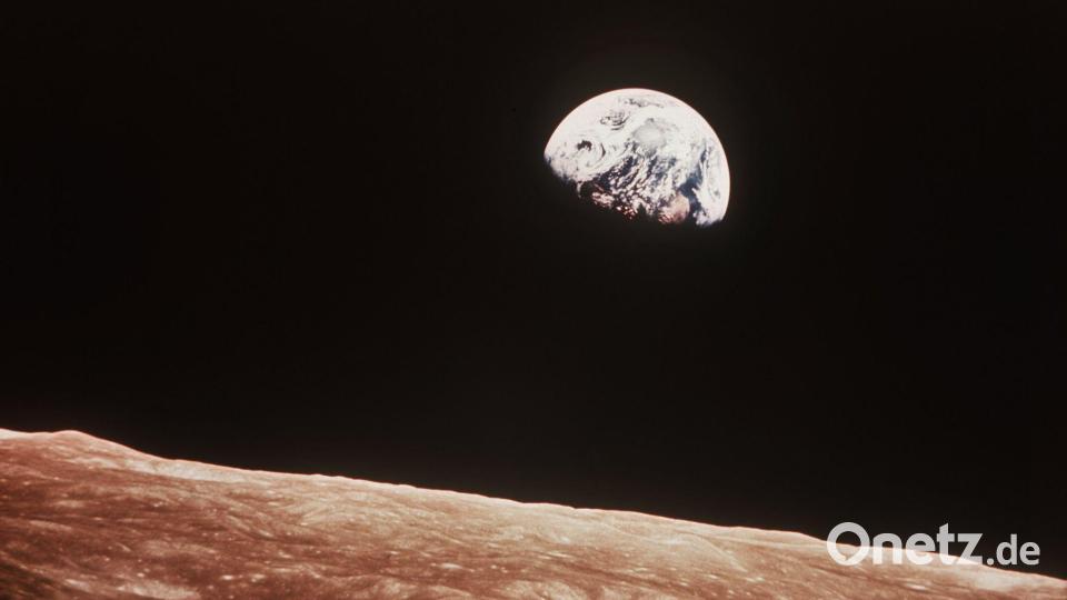 Blick über die Mondoberfläche auf die Erde, aufgenommen im Dezember 1968 von der Apollo 8-Besatzung aus etwa 780 km Höhe. Eher zufällig gelang William Anders am Heiligabend 1968 ein Foto, das die Sicht der Menschheit auf unseren Planeten für immer verändern sollte\ „Earthrise“, die kleine aufgehende Erde über dem Mondhorizont. 2026 feiert die Fotografie ihr 200-jähriges Jubiläum. Bild: NASA/dpa